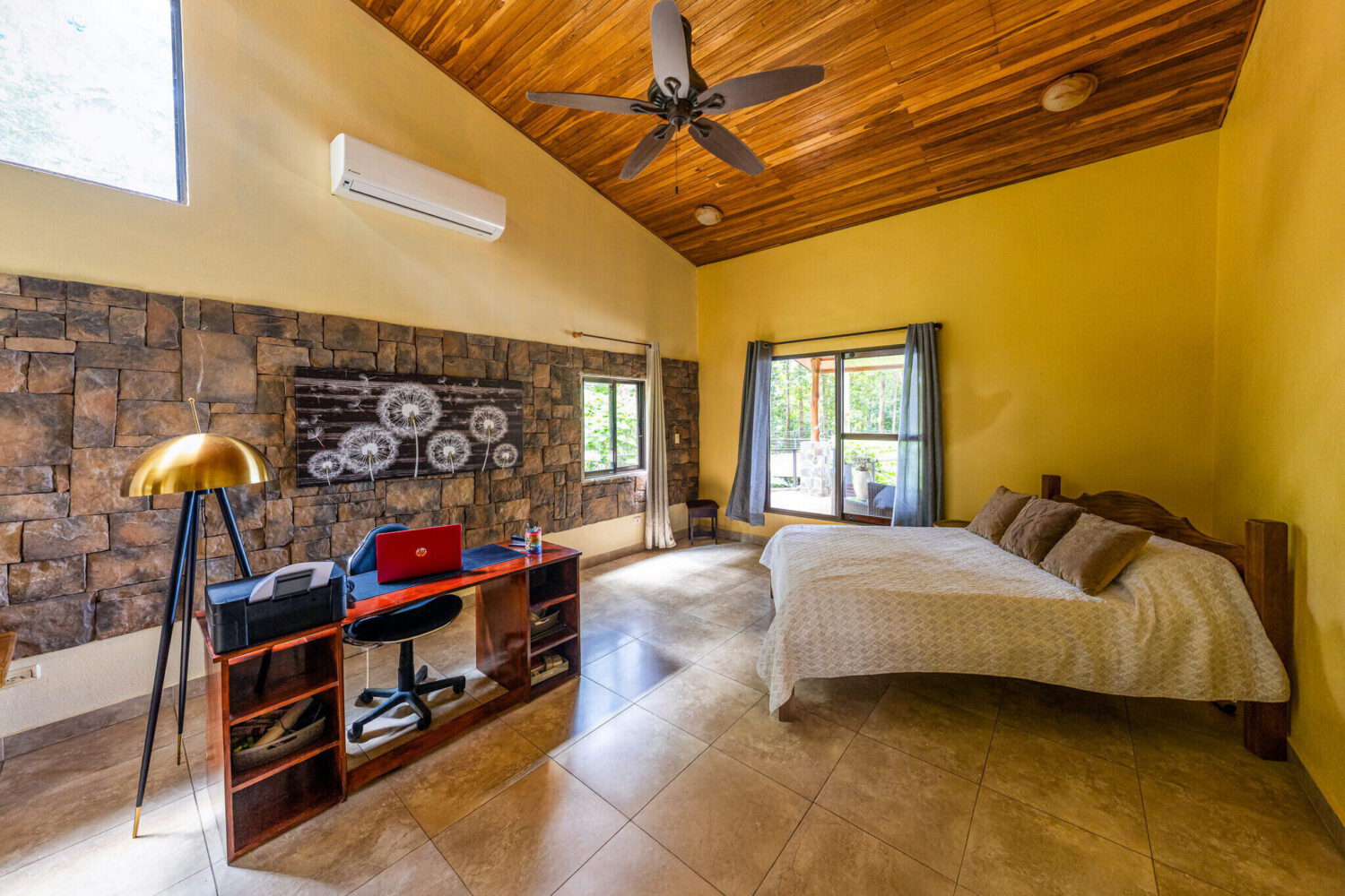 Bedroom with a timber ceiling and stone accent wall