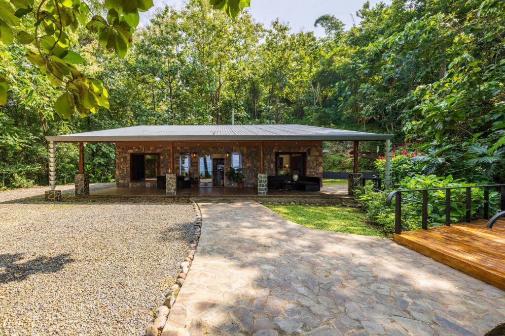 Covered stone terrace with rancho seating beside the garden