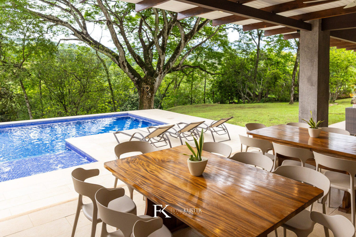 Poolside dining terrace shaded by mature trees