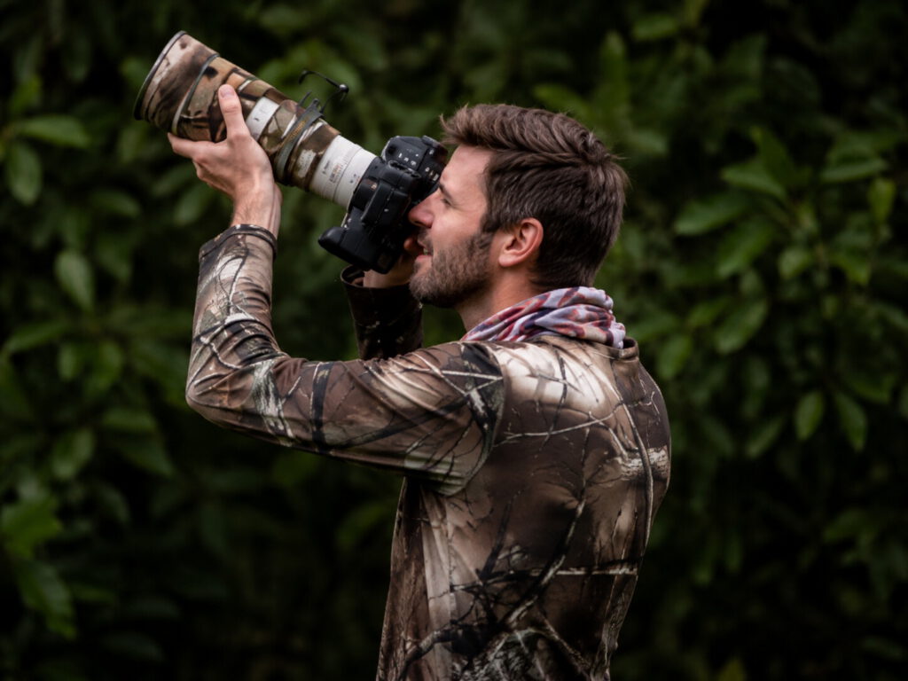 A photographer with a telephoto lens working against dense forest foliage in Costa Rica