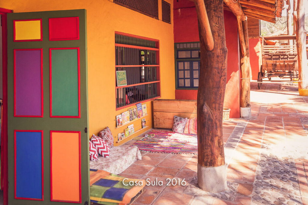 A classroom with brightly painted doors, bookshelves and floor cushions