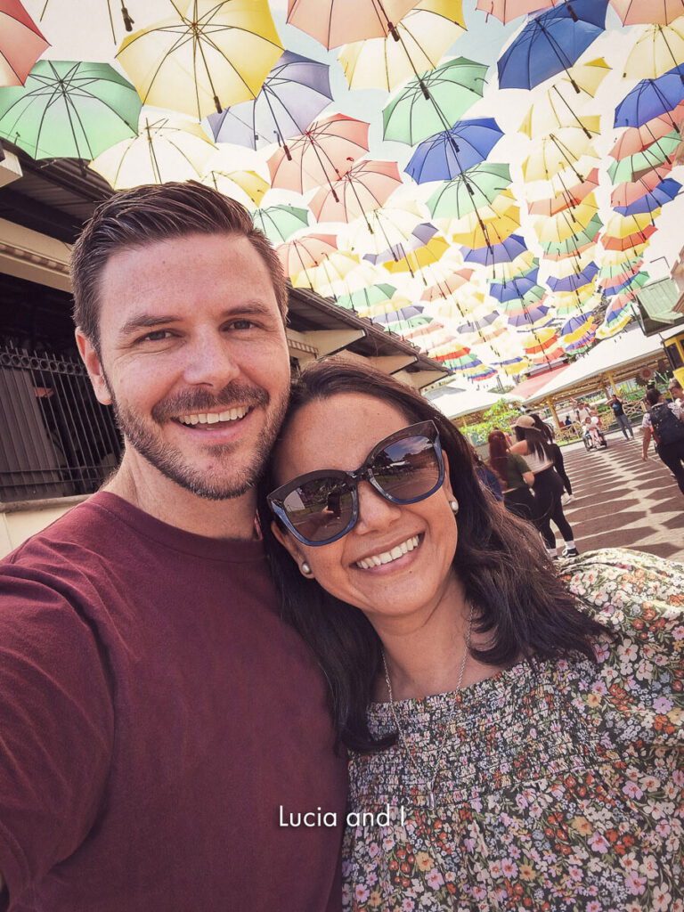 Florian and Lucia Kuster together beneath a canopy of coloured umbrellas