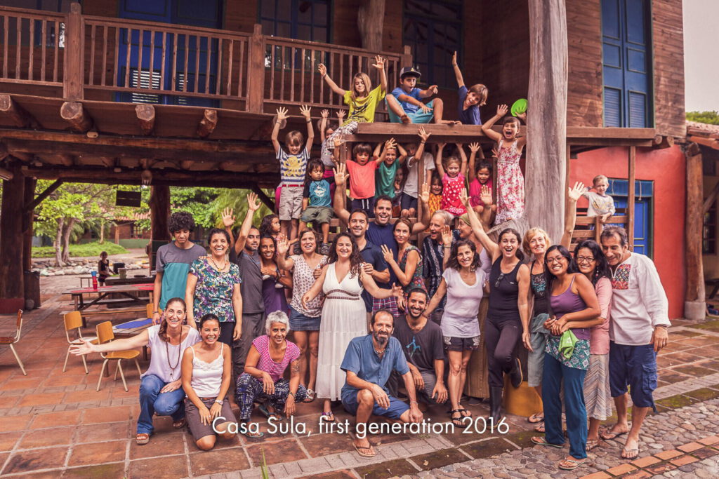 A large group of families gathered on the steps and balconies of a red building